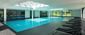 Indoor pool with a large skylight and rows of loungers