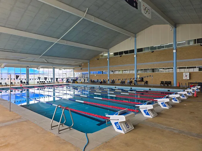 Indoor 25 m pool hall with lane ropes and starting blocks