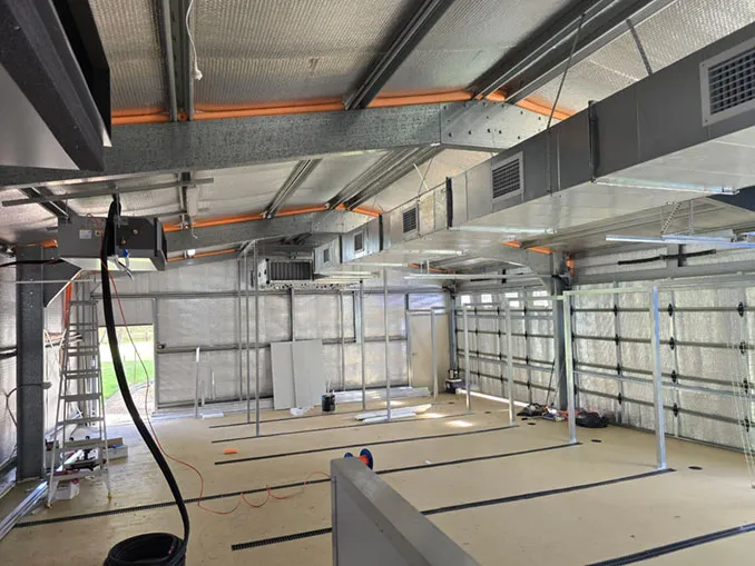 Galvanised supply ductwork being installed under the roof of a commercial building
