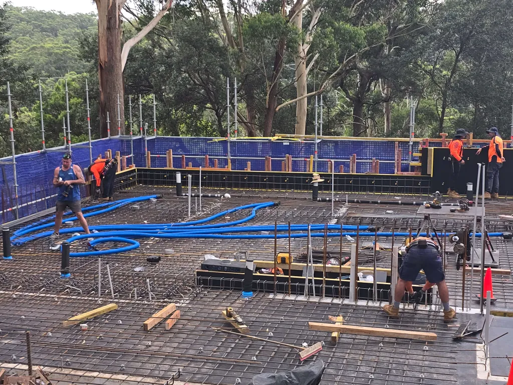 Concrete pool shell under construction with reinforcement and in-slab pipework