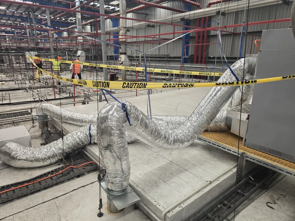 Insulated flexible ductwork being installed on a commercial construction site