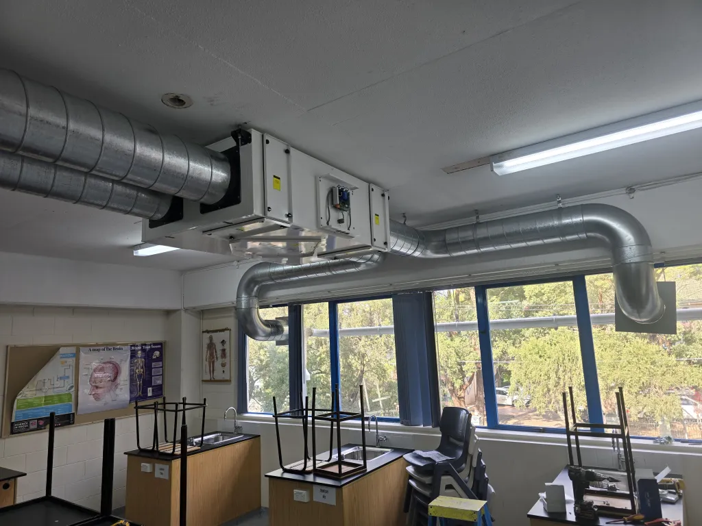 Ceiling-mounted heat recovery ventilation unit and spiral ducts in a science classroom