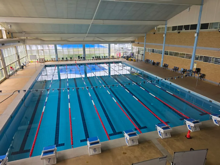 Indoor 50 m competition pool hall with lane ropes and starting blocks